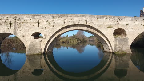 Flying-trough-an-arch-of-pont-vieux-river-Orb-in-Beziers.-Old-bridge